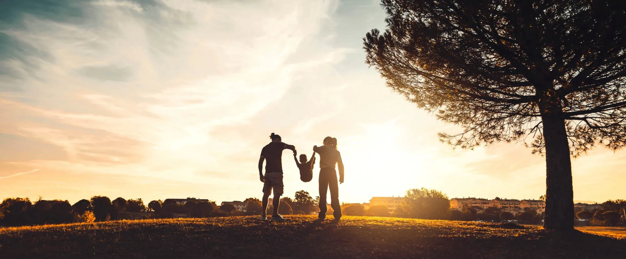 Family playing with their child at sunset